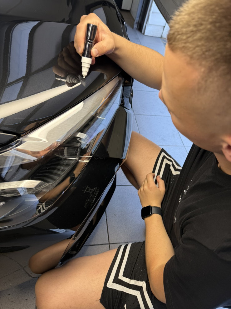Uzupełnianie odprysku lakierem przy reflektorze